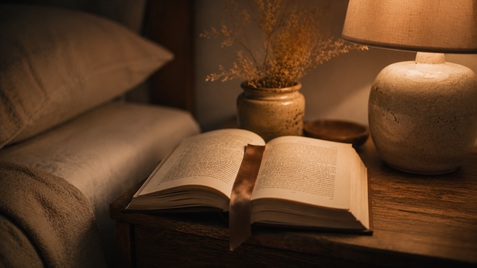 Livro aberto na mesinha de cabeceira